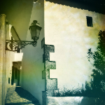 Photographie d'une ruelle étroite dans le village de Salir. Le sol pavé de petits carreaux en pierre noire et blanche.