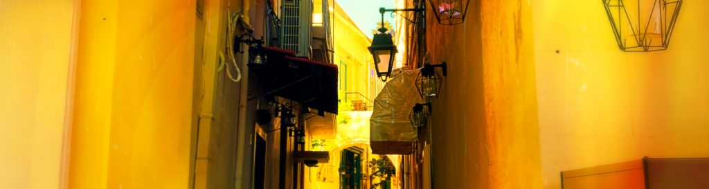 Photographie d'une ruelle de la ville de Rethymnon, ses terrasses de cafés, ses petites échoppes.