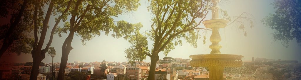 Photographie d'une fontaine en pierre à Lisbonne. Son eau fraîche aux reflets bleu et vert.