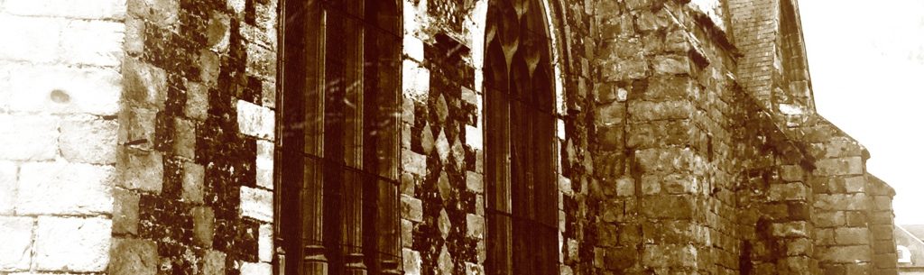 Photographie du mur d'une église noircie par le temps.