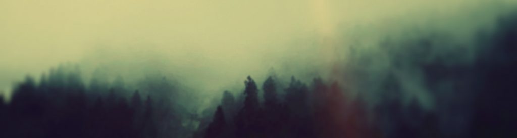 Photographie d'une montagne embrumée au couché du soleil.