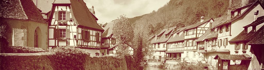 Photographie du village de Kaysersberg en Alsace avec la rivière au pied des maisons.