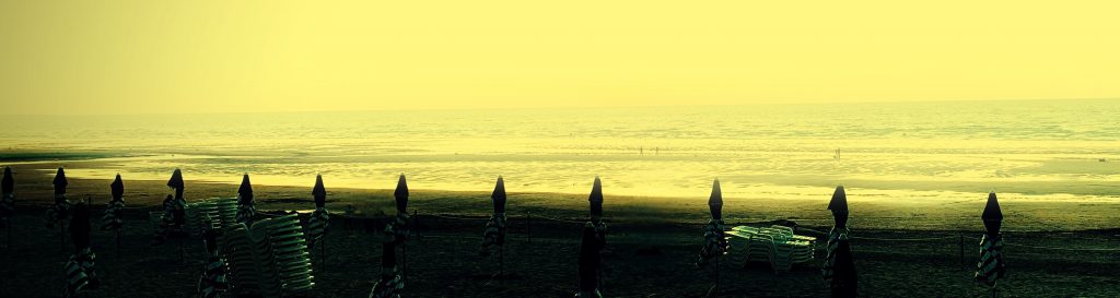 Photographie de la plage de Cabourg avec ses parasols et la mer en arrière plan.