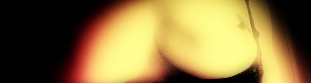 Photographie de Sarah, nue encorsetée dans de la dentelle noire.