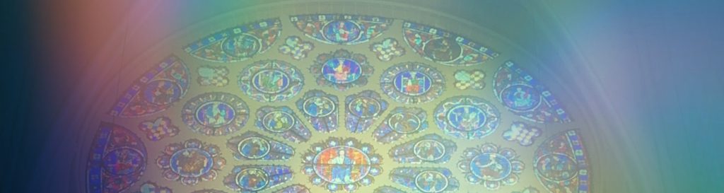 Photographie d'un vitrail en forme de rosace représentant le jugement dernier.