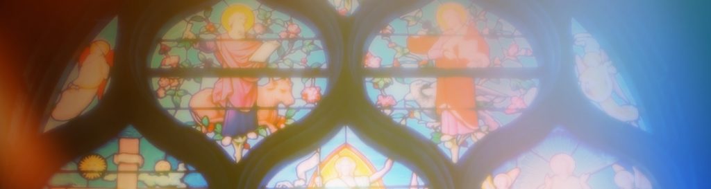 Photographie d'un vitrail coloré reflétant la lumière divine.