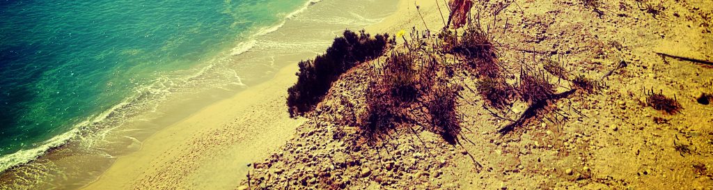 Photographie de l'océan atlantique vue d'une falaise. Le sable doré, les vagues.