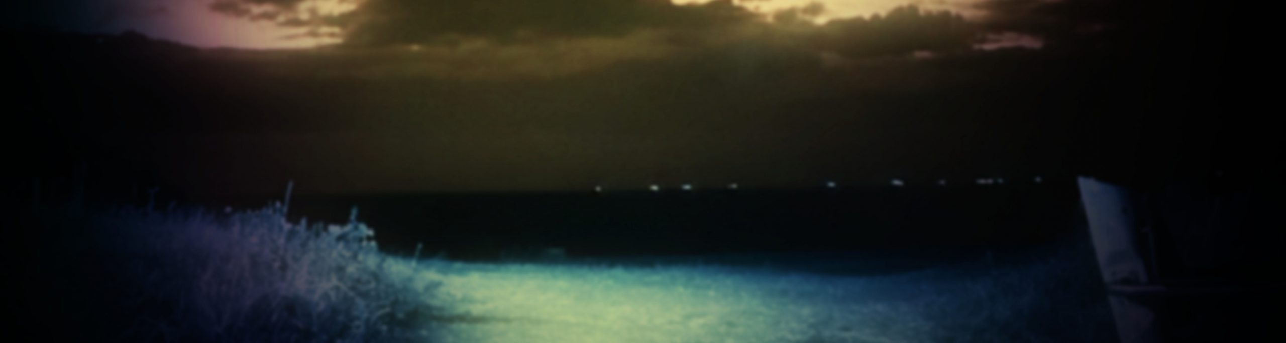 Photographie représentant la plage de Cabourg une nuit d'été. La lune éclaire le sable.