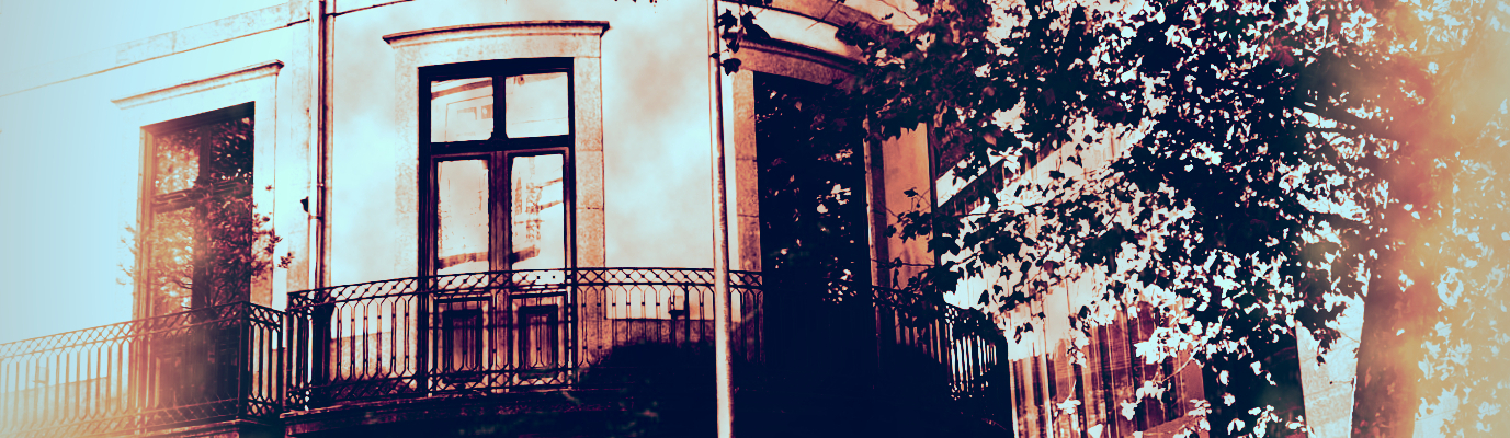 Photographie d'un appartement à Porto. La construction est ancienne, les murs de formes arrondie. un arbre cache la lumière du soleil.