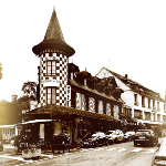 Photographie du rue de bagnoles de l'orne. Au premier plan, la tourelle aux motifs à damier d'un hôtel.
