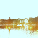 Photographie des termes de Bagnoles de l'Orne. Au premier plan le lac et au fond les termes entouré d'arbres.